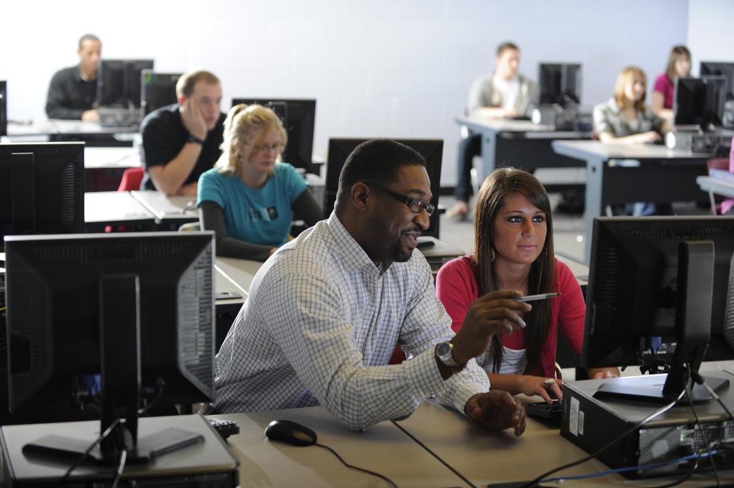 Tyson works with a student at a computer